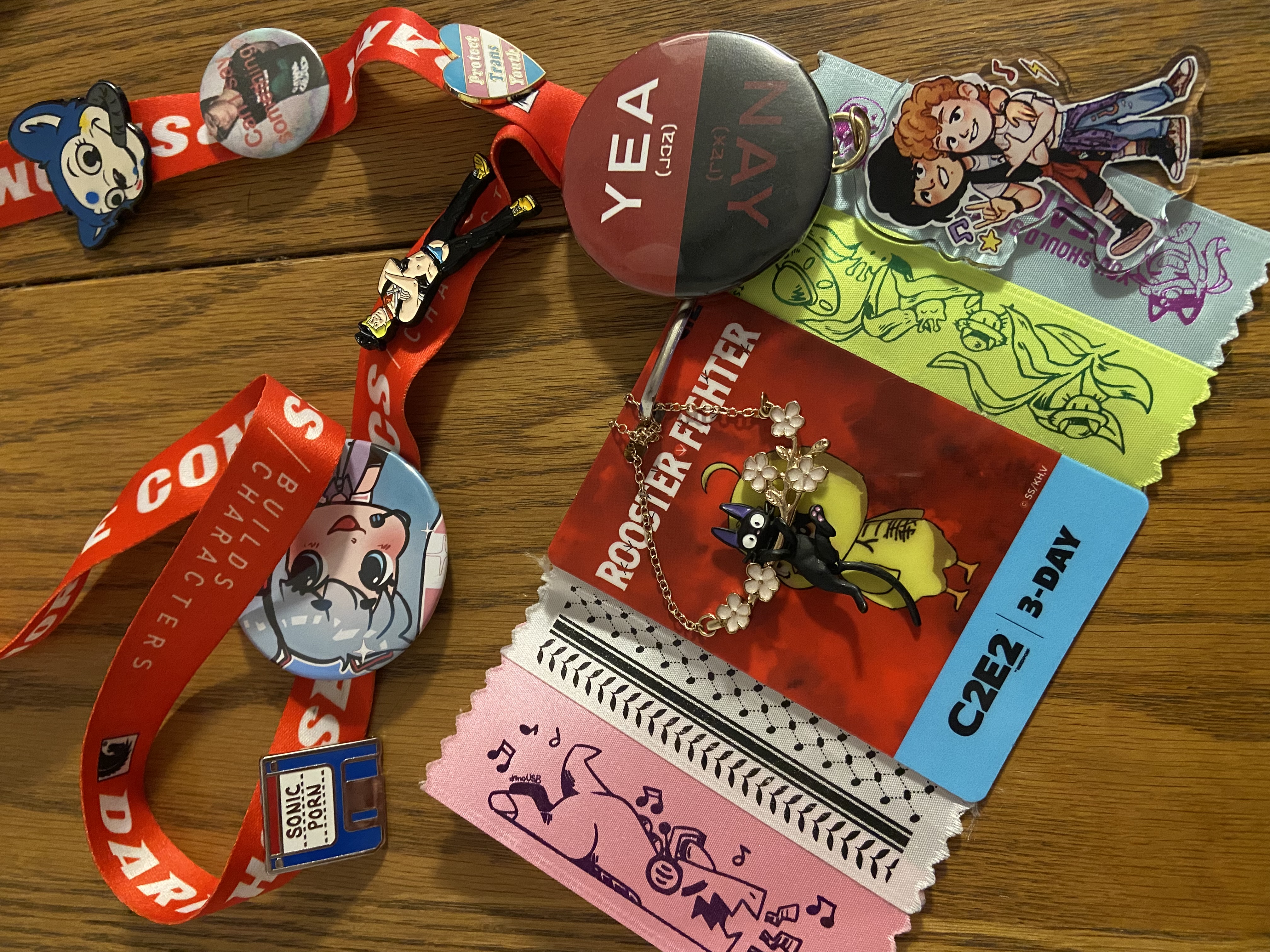 a c2e2 badge with a few ribbons on the badge itself and pins and buttons on the lanyard