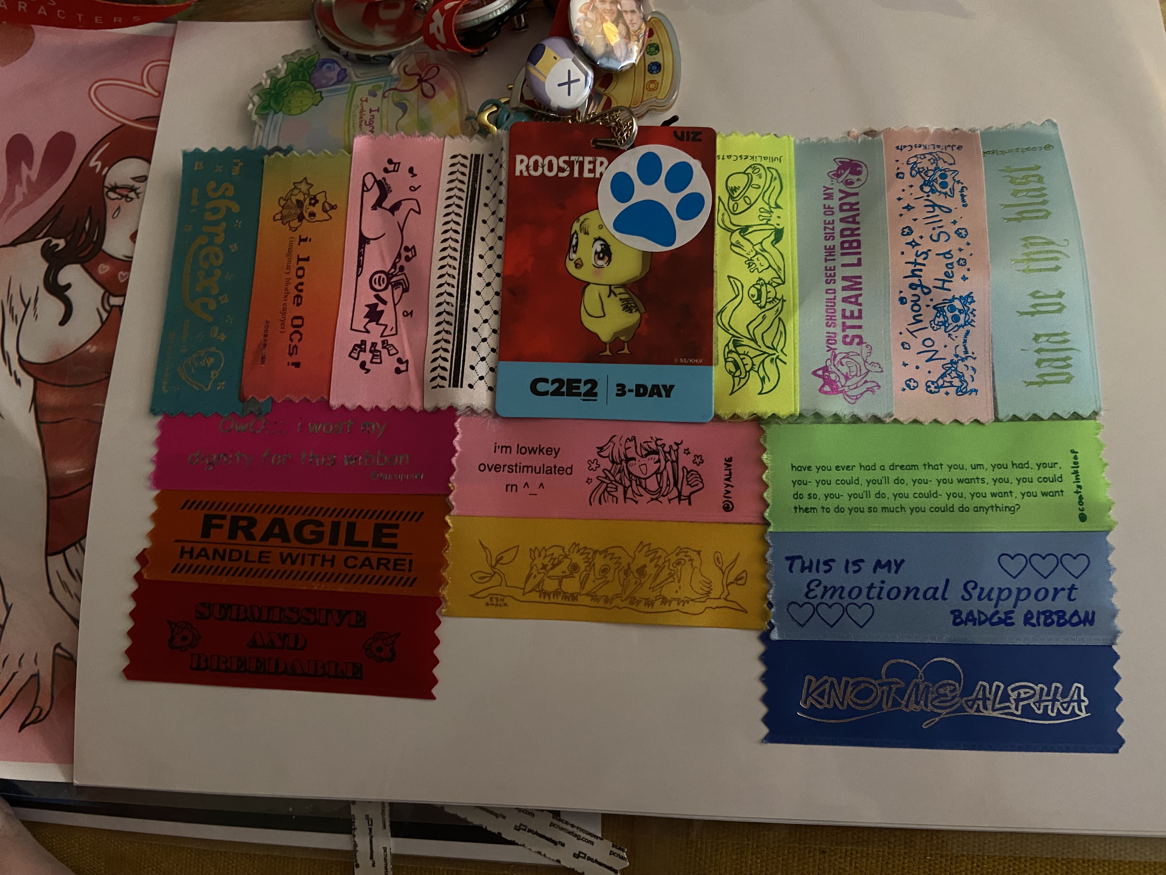 a c2e2 badge with lots of pins and buttons on the lanyard and ribbons on the badge itself. there are acryllic keychains on the lanyard as well