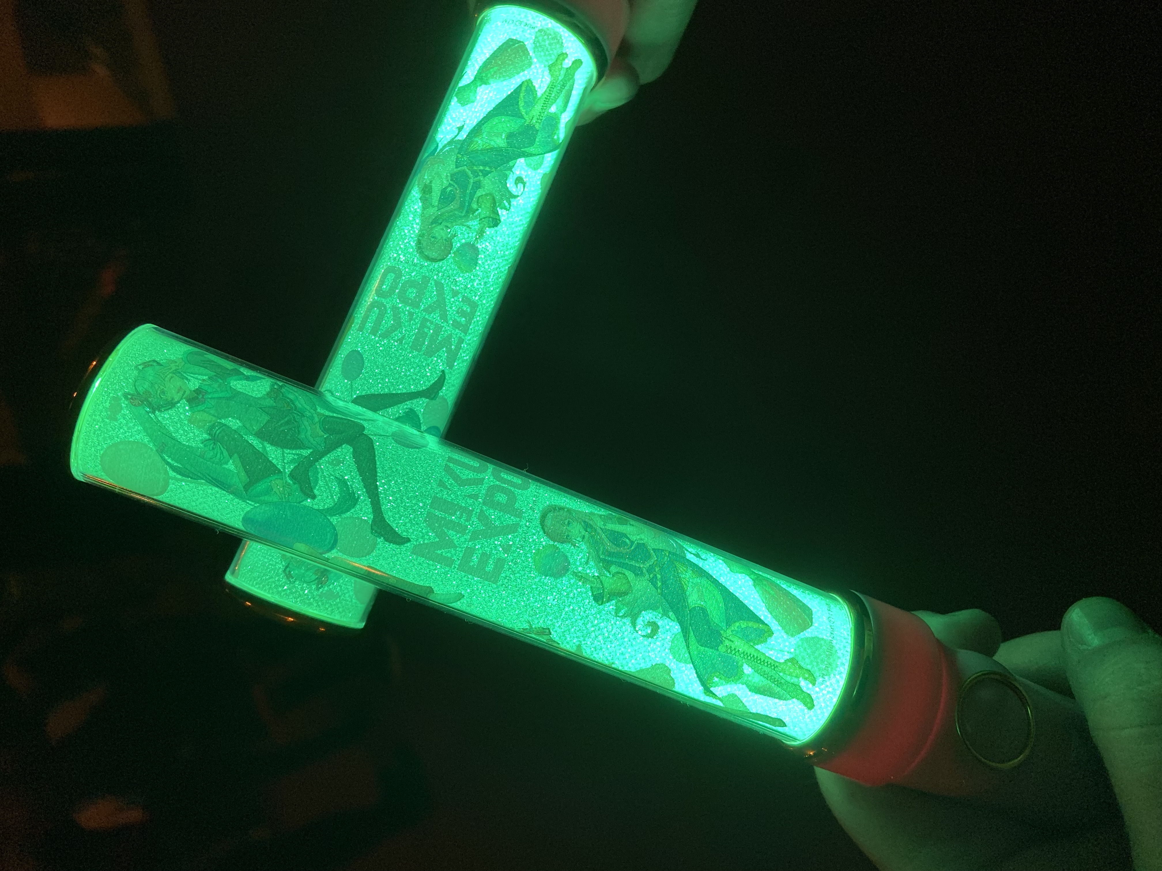 two miku light sticks in front of a portion of the chicago skyline